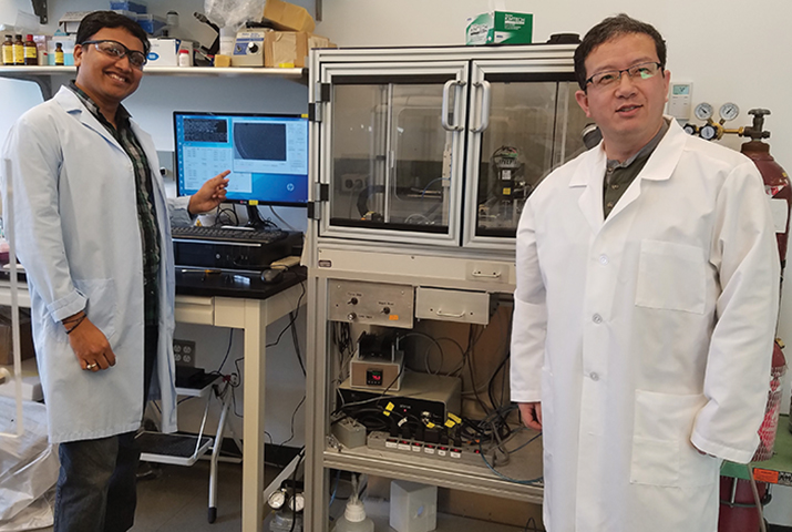 The Spotiton robot operated by Venkata Dandey (left) and Hui Wei (right) in the Carragher lab.