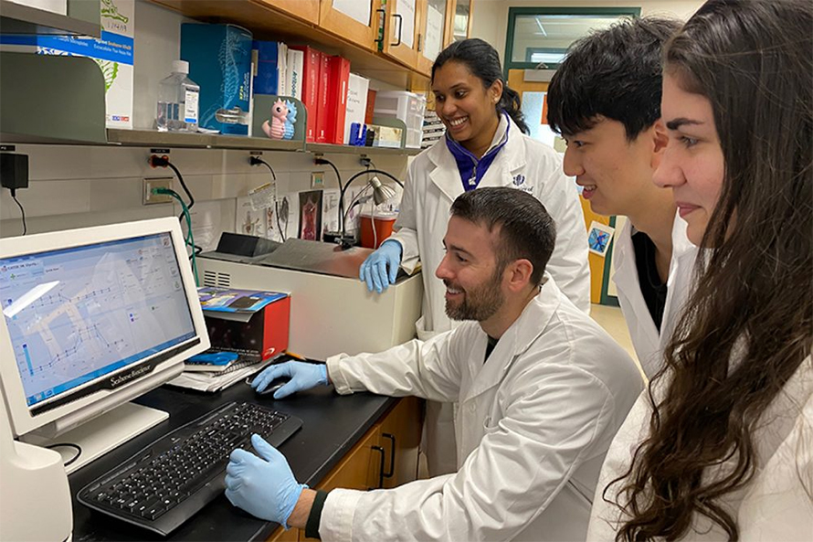 Associate professor of nutritional sciences Christopher Blesso (seated) with students in the Department of Nutritional Sciences in the College of Agriculture, Health and Natural Resources.