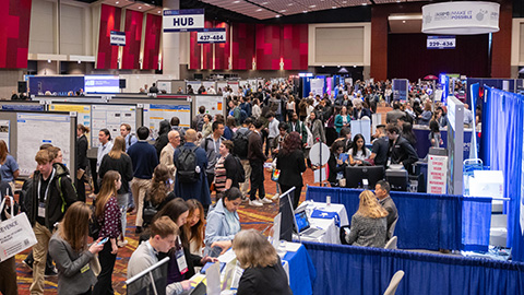 An exhibitor talking with a conference attendee