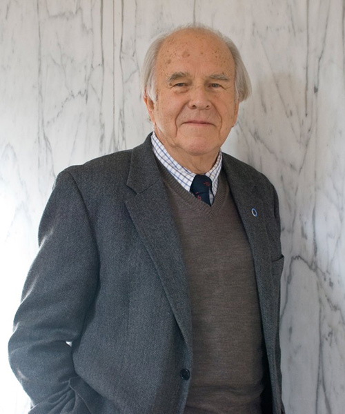 Portrait of Franz Matschinsky leaning against a marble wall.