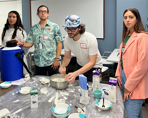 Suspects in the crime scene DNA investigation outreach event at the University of Miami, Laura Pelaez, Joey Shulz, Tate Pollock and Maddison Marshall, gather around a station to show how ice cream can be made using liquid nitrogen.