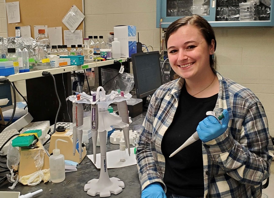 A portrait of Danielle Whitham in the lab at Clarkson University with her new set of pipettes.