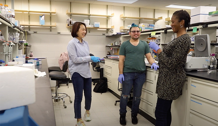 Denise Okafor, right, chats with two members of her lab at Penn State. The group focuses on the famesoid X receptor.