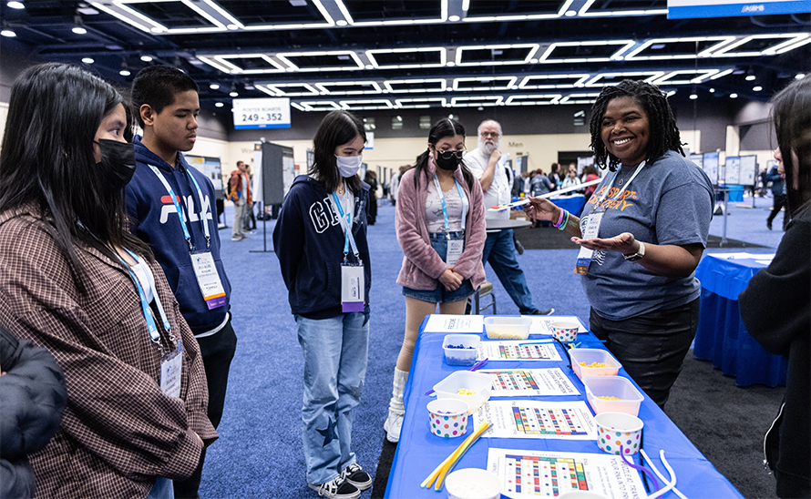 ASBMB Science Outreach and Communication Committee member Odaelys Pollard, left, talks to Seattle-area high school students at the Community Day “Escape the Cell” station, one of several hands-on activities.