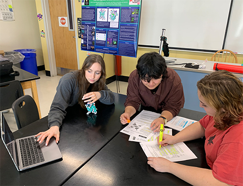 From left, Greta Wedel, Kimy Hernandez and Abi Ferguson, seniors at Longmont High School in Colorado, discuss their SMART Team project in late January, as they gear up to present at Discover BMB in Seattle.