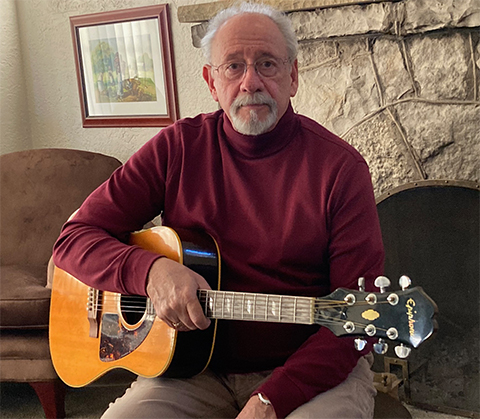 Blaise Arena holds one of his guitars.