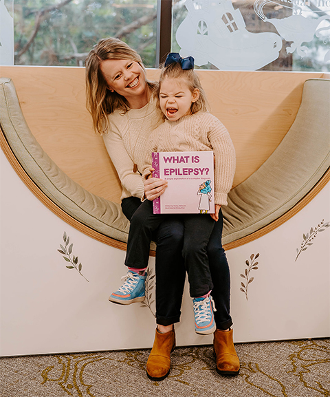 Hailey Adkisson and daughter Juniper, age 4, pose with the book Adkisson wrote to explain epilepsy to children.