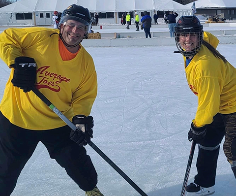 Joseph Provost and his daughter, Kristina Provost, cross sticks in the Fargo Pond Hockey Tournament.