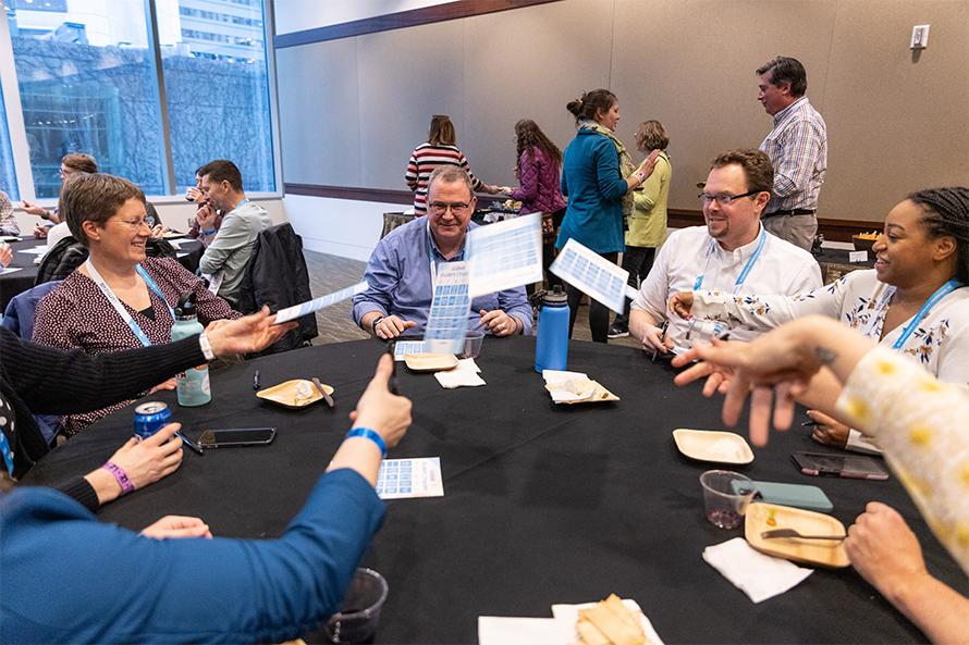 Kim Dickson of Lawrence University, John Tansey of Otterbein University, John Weldon of Towson University and other undergraduate faculty members get to know each other during a round of BINGO at the 2023 Undergraduate Faculty Reception in Seattle.